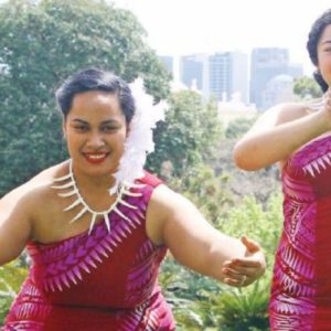 four samoan woman in bright pink traditional costume dancing