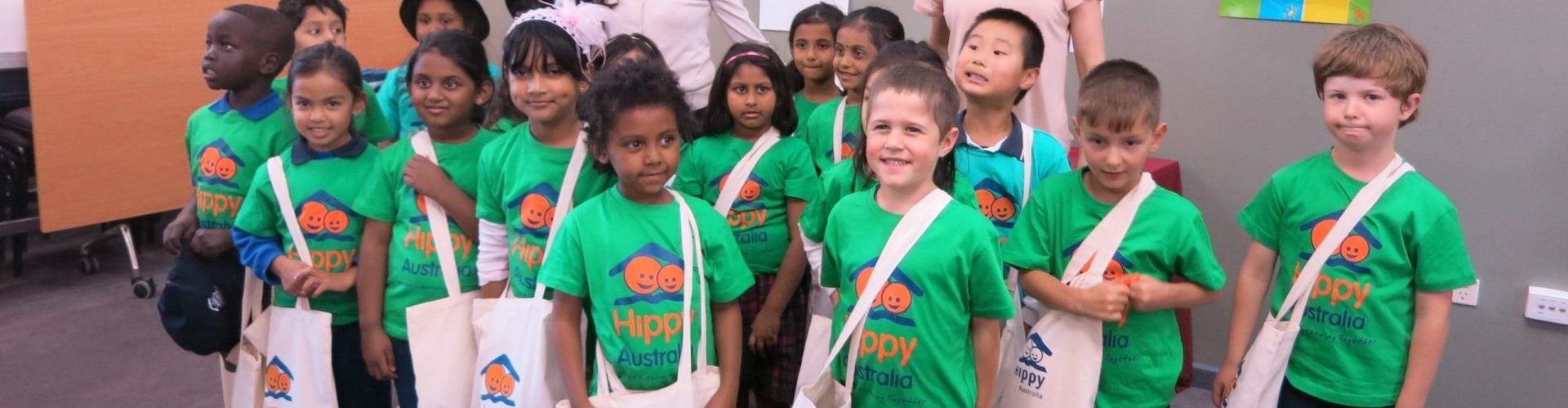 group of children wearing HIPPY program t-shirts smiling at camera