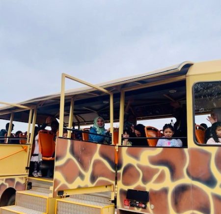 HIPPY gathering with people on a bus painted like a giraffe Image