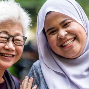 two woman of different ethnic background smiling at camera