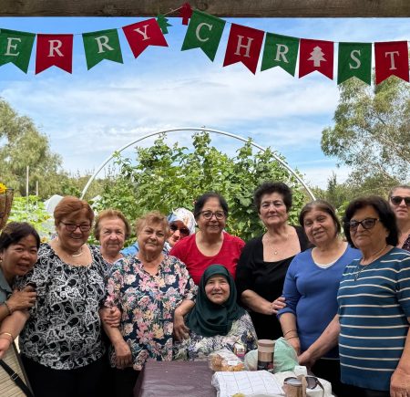 A group of women smile at the camera. They are gathered together at the hive Image