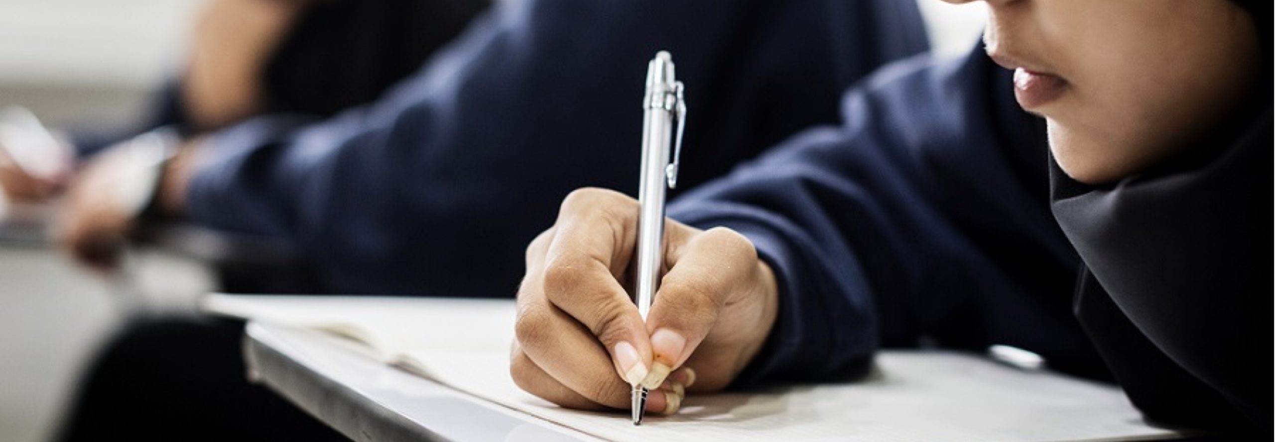 A student writing on a notebook