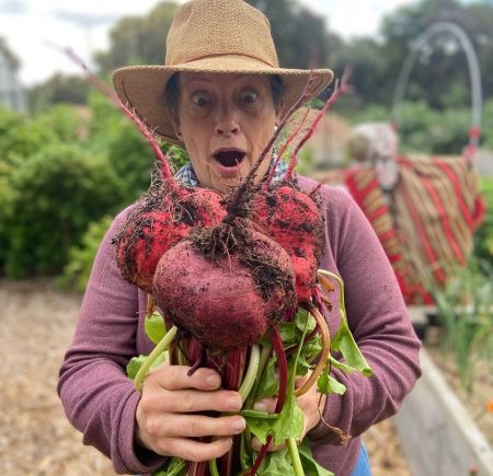 A woman holding up beetroot Image