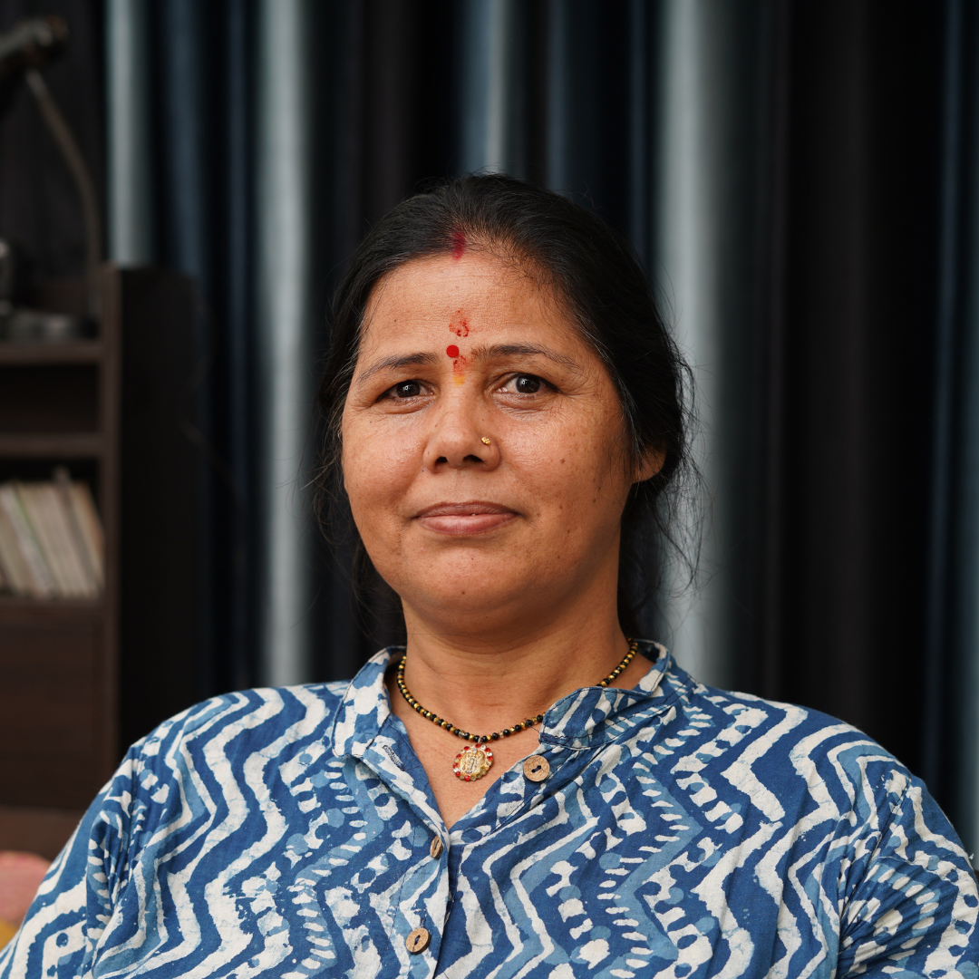 A South Asian woman smiles softly at the camera