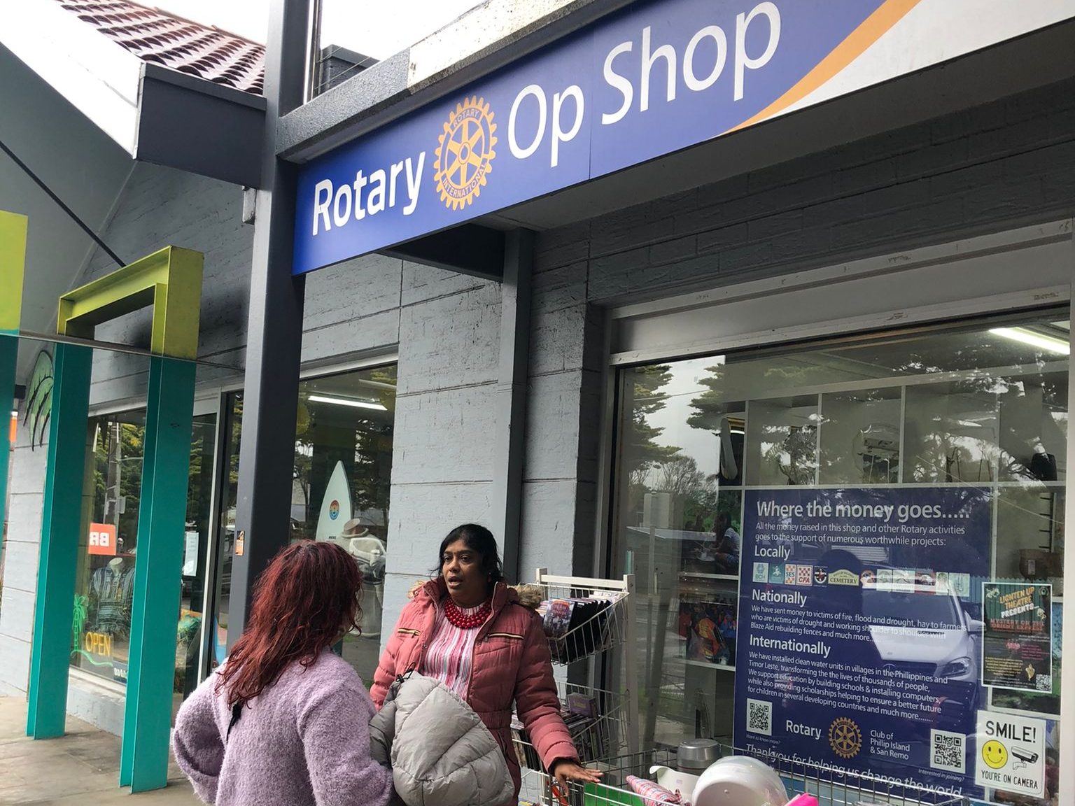 Two women stand outside the Rotary Op Shop