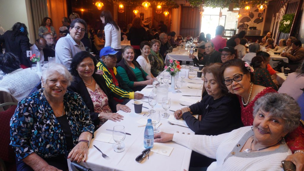 People sitting across a long white table smiling at the camera