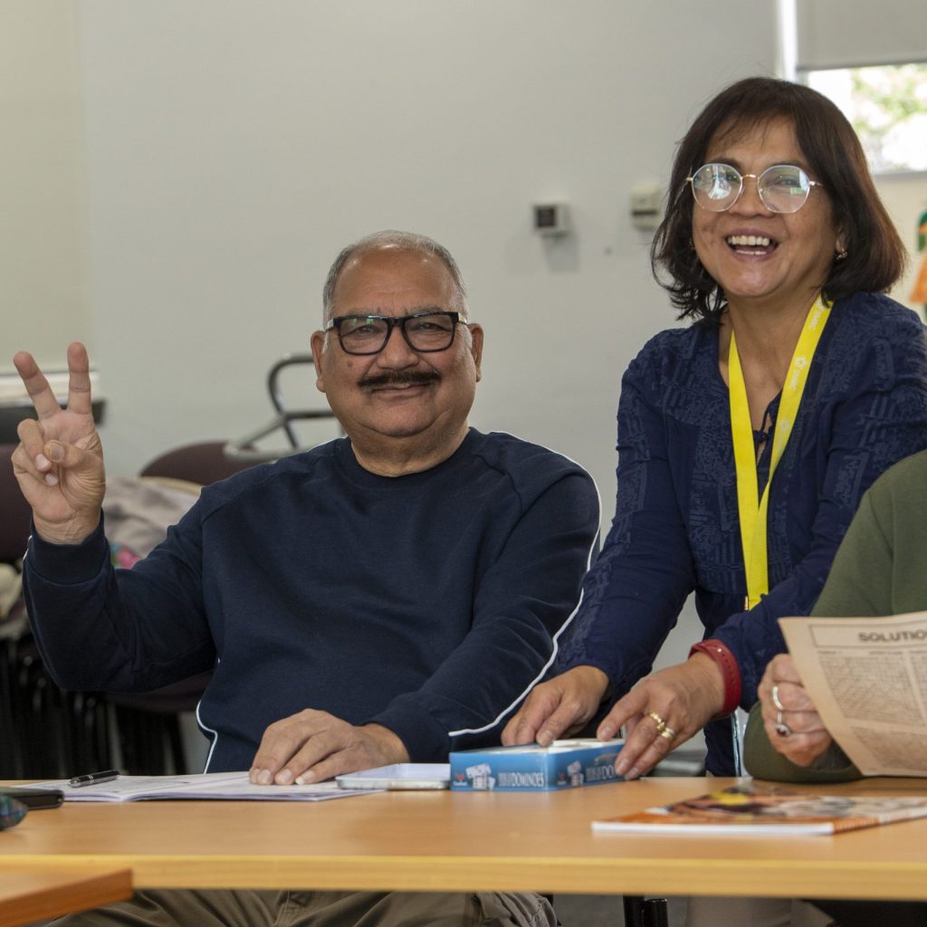 A man and woman smile at the camera