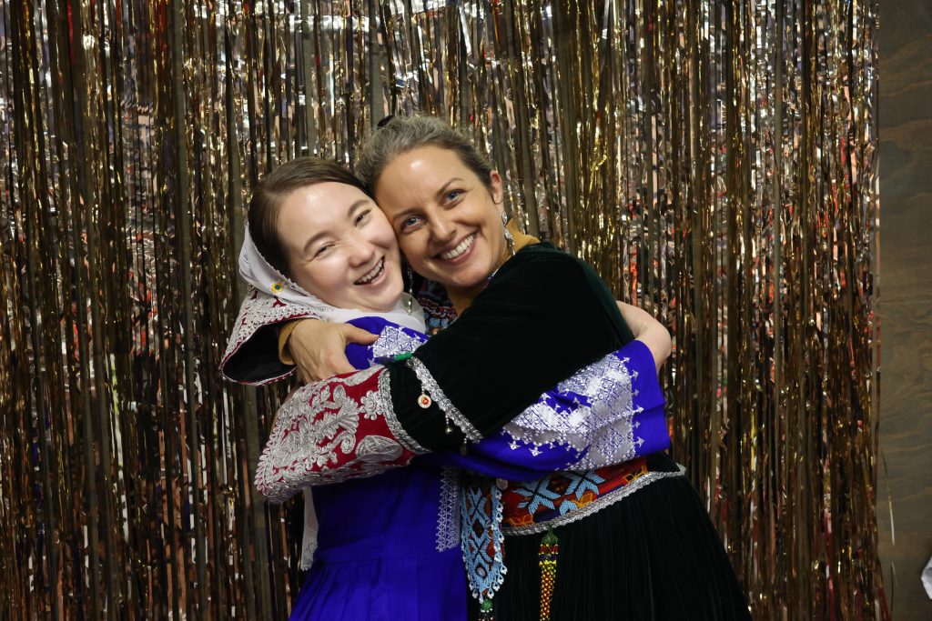 Two women share a hug and smile at the camera